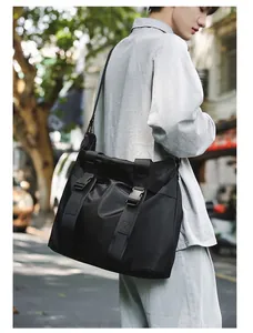 Lifestyle-Detail einer großen schwarzen Kuriertasche, getragen von einem männlichen Model