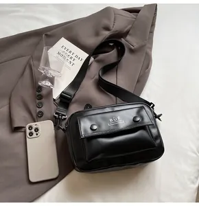 Detalle de un bolso bandolera vintage negro con solapa delantera y el logotipo BUF