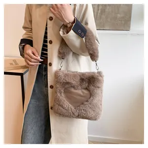 Dettaglio di una borsa tote in peluche marrone con cuore abbinata a un cappotto beige