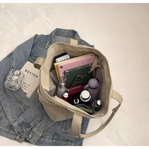 Vista interior del bolso tote de nailon beige que muestra gran capacidad para tabletas