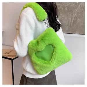 Borsa a tracolla in ecopelliccia verde neon con dettaglio a cuore indossata da modella
