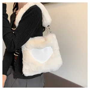 Dettaglio di una borsa tote bianca in pelliccia sintetica con un grande motivo a cuore.