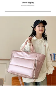 Large pink metallic quilted travel bag shown being held by a model in casual setting
