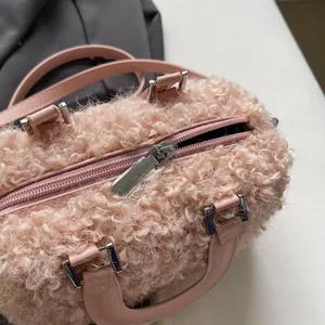 Close-up detail showing the soft pink teddy fur and silver zipper of this chic handbag