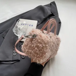 Detail shot of a pink faux fur box handbag with elegant shoulder strap and handle.