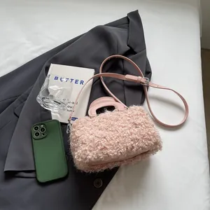Detailed view of a pink faux fur square handbag with an adjustable leather strap