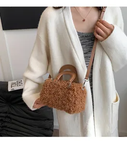 Detail view of stylish brown fuzzy sherpa handbag styled with a white knit cardigan