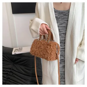 Close-up of a brown fuzzy faux fur handbag with top handles and shoulder strap