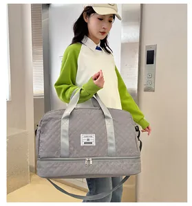Detail of gray quilted travel bag with bottom shoe compartment and shoulder strap