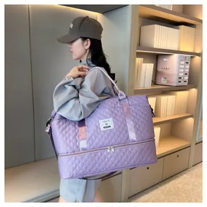 Purple quilted travel bag with shoe compartment shown being carried by a model