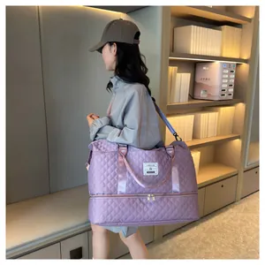 Detailed lifestyle view of a purple quilted travel duffel bag carried by a model