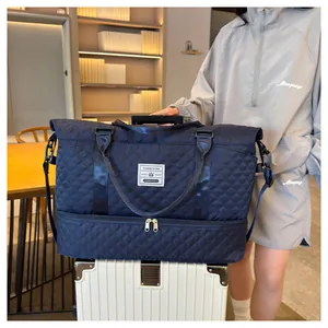 Detail showing navy quilted travel bag secured on a white rolling suitcase handle