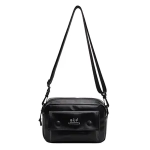 Primer plano de minibolso bandolera negro vintage con bolsillo frontal y correa ajustable