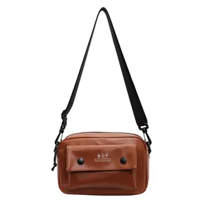 Primer plano detallado de un bolso cuadrado vintage marrón con correa ajustable.