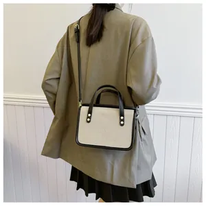 Gros plan détaillé d'un sac à bandoulière en toile minimaliste avec un blazer.