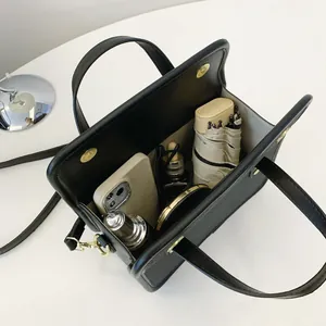 Vue détaillée montrant la grande capacité interne d'un sac à main noir minimaliste