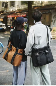 Lifestyle-Ansicht zweier großer Reisetaschen in Braun und Schwarz in einer Straße.