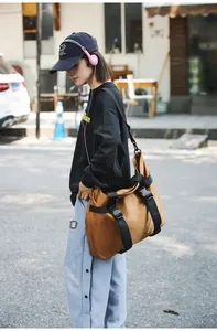 Detailansicht einer großen braunen Reisetasche, getragen von einem Model im Freien