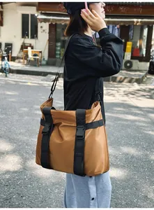 Große braune Nylon-Reisetasche im Outdoor-Straßenstil als Umhängetasche getragen