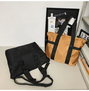 Große schwarze und braune Nylon-Reisetaschen in einer Lifestyle-Schreibtischszene