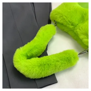 Dettaglio di una borsa tote in ecopelliccia verde neon con tracolla soffice e morbida