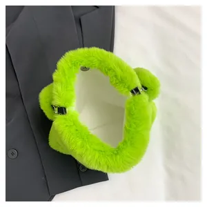 Primo piano della borsa tote verde pelosa che mostra la texture e la fodera bianca.