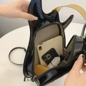 Detailed view of guitar-shaped patent leather bag interior showing storage capacity