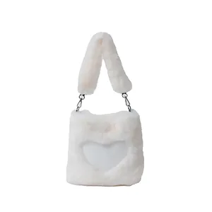 Primo piano di una borsa tote in peluche bianca a forma di cuore con tracolla morbida.