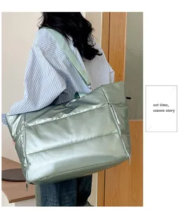 Large metallic mint green puffer travel bag with dual front zippers and wide strap