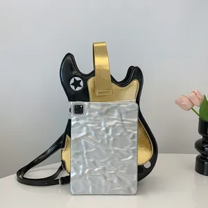 Detail view of guitar-shaped crossbody bag with metallic gold and black contrast design