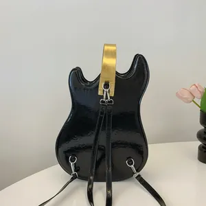 Guitar-shaped black patent leather backpack with gold handle and silver hardware