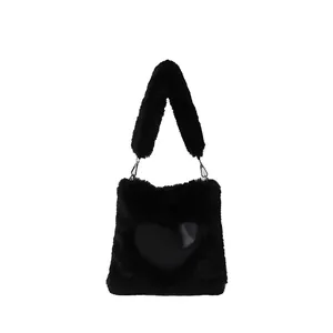 Primo piano di una borsa tote in peluche nera con una toppa a cuore liscia.