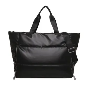 Detail view showing the full front of a large black quilted puffer travel tote bag.