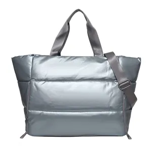Large metallic silver quilted travel tote bag featuring an adjustable shoulder strap