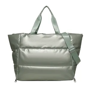 Large sage green quilted travel tote bag with metallic finish and adjustable shoulder strap