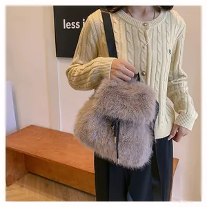 Macro view of a soft plush faux fur bucket bag worn by a model in a cozy winter setting