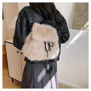 Back view of a stylish beige faux fur backpack on a model wearing a leather jacket.