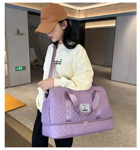 Large purple quilted gym bag with wet and dry separation carried by female model