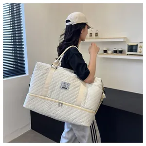 Stylish white quilted travel bag with shoe compartment carried by a model for scale