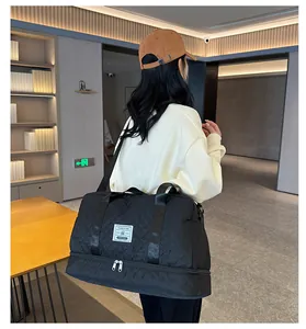 Large black quilted travel duffel bag with wet-dry separation shown in a lifestyle setting