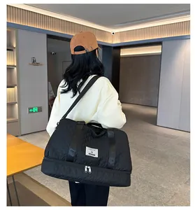 Back view of a woman carrying a black quilted travel bag with shoe compartment