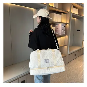 White quilted travel bag with shoe compartment shown carried by model.