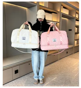 Model holding pink and white quilted travel duffle bags with dry wet separation