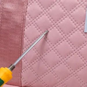 Macro detail of pink quilted fabric with diamond stitching on a sports travel bag