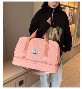 Close-up of a pink quilted sports duffel bag held by a model showcasing its stylish design