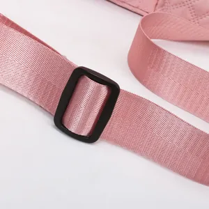 Close-up of durable pink nylon strap and black plastic buckle on a quilted sports bag