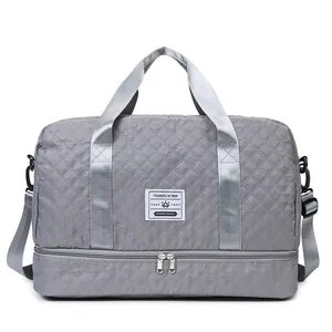 Grey quilted travel duffel bag featuring a separate bottom shoe compartment and strap.