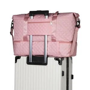 Close-up detail of pink quilted travel bag sleeve fitting over white luggage handle.