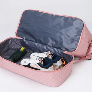 Detailed interior view showing the separate shoe compartment of the pink quilted travel bag