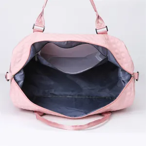 Internal detail view of pink quilted gym bag showing a spacious main compartment and pocket